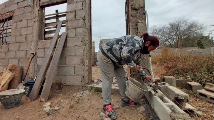 Mujer haciendo su hogar ladrillo por ladrillo