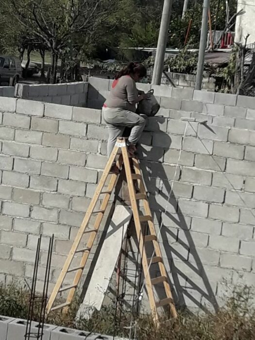 Mujer haciendo su hogar ladrillo por ladrillo