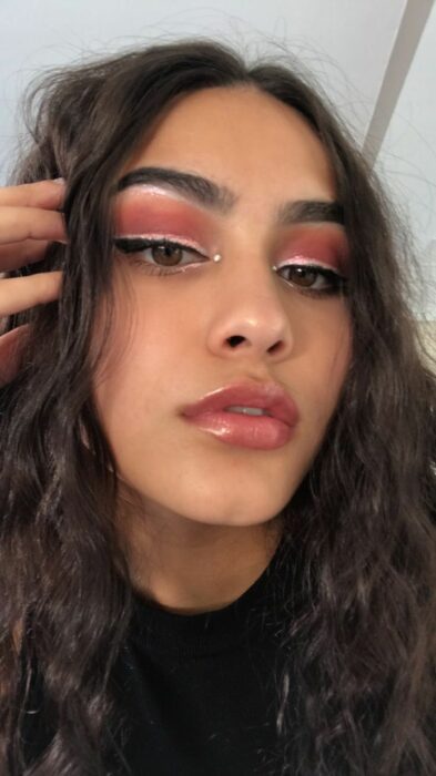 Chica usando un maquillaje con brillos
