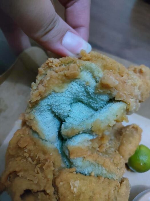 Chica abriendo un pollo frito que en realidad era una toalla