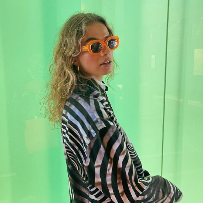 chica posando en una pared llamativa con gafas