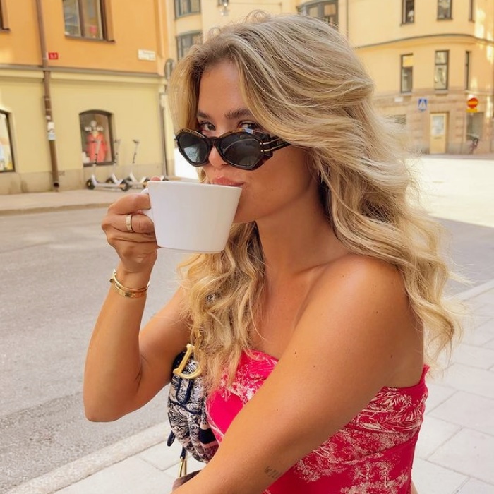 chica disfrutando de un café con gafas de sol