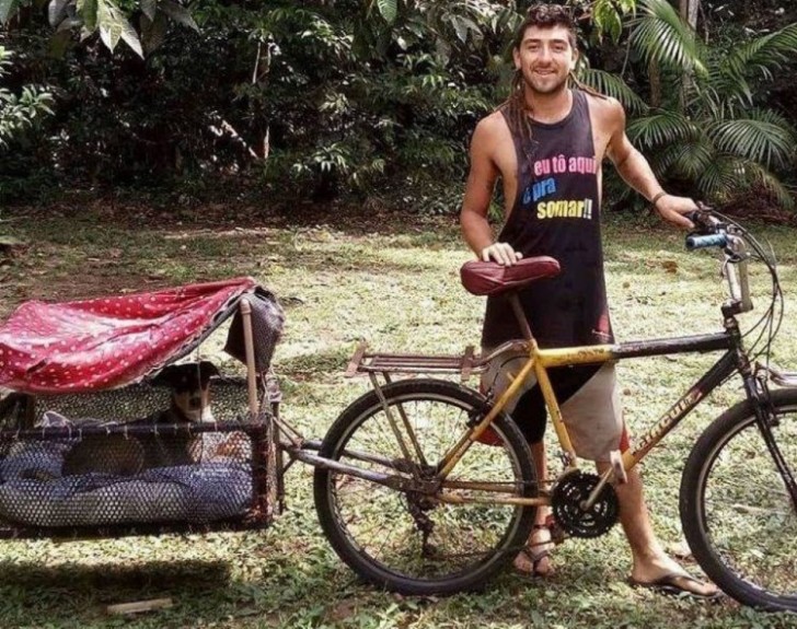 Hombre posando junto a su perrito mientras muestra su bicicleta con una canastilla