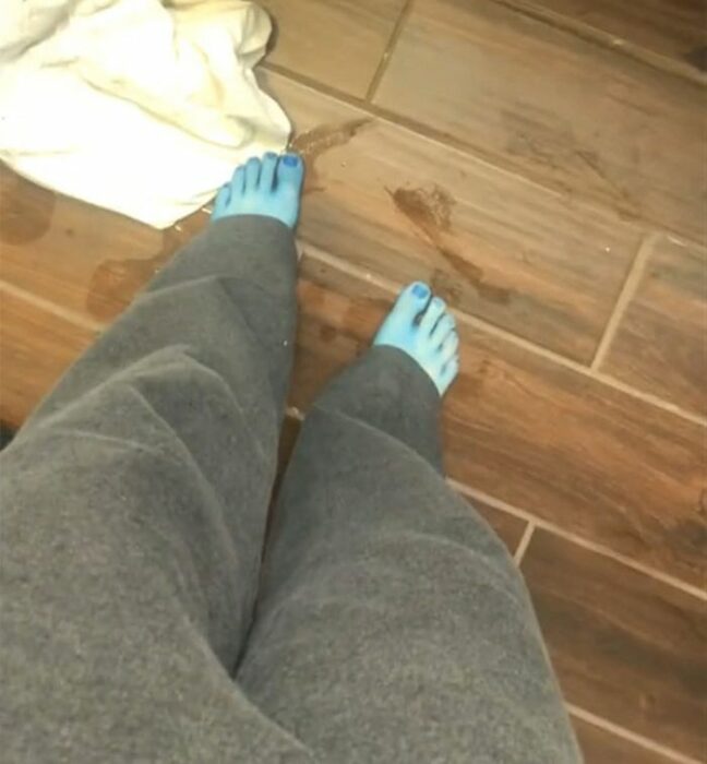 Chica mirando su cuerpo teñido de azul al teñir su cabello