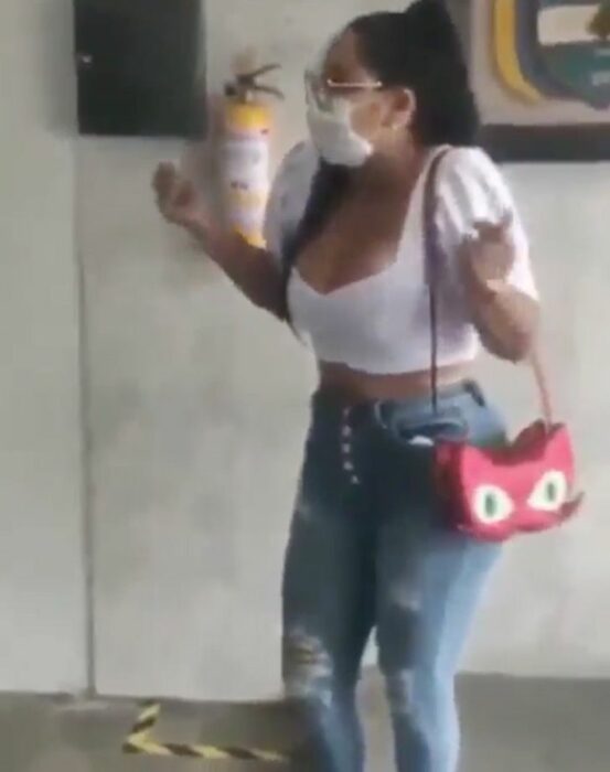 Mujer usando jeans y blusa blanca mientras está en una escuela 