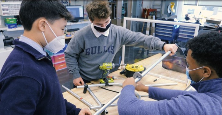 Estudiantes creando un soporte en un laboratorio 