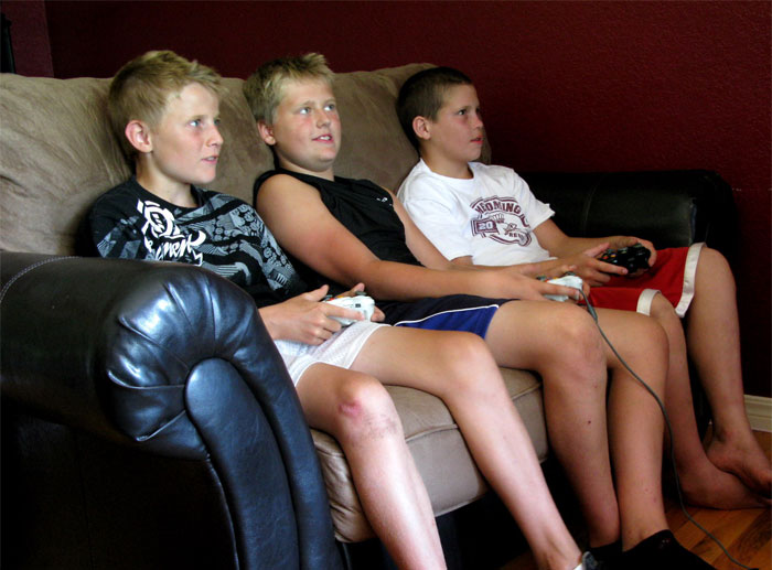 Niños sentados en una sala jugando Xbox 