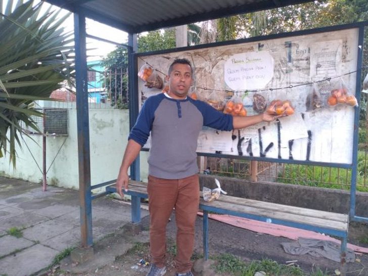 Chico frente a una parada de autobús; Vecinos dejan fruta y pan en una parada de autobús para los más necesitados