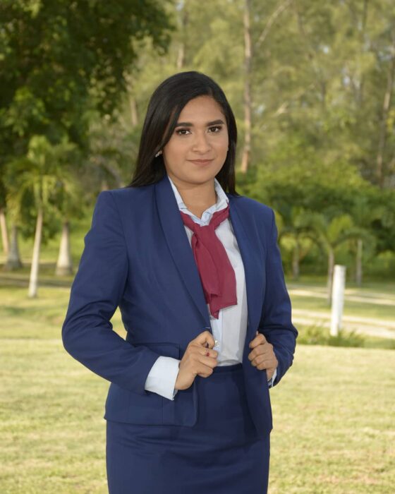 Evelin Hipólito con traje sastre en su graduación; Chica posa orgullosa con su título universitario en el banco donde vendía dulces
