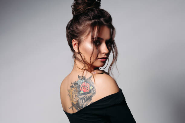 chica mostrando el tatuaje de su espalda; 4 Tips para cuidar tus tatuajes y no sufrir en el intento