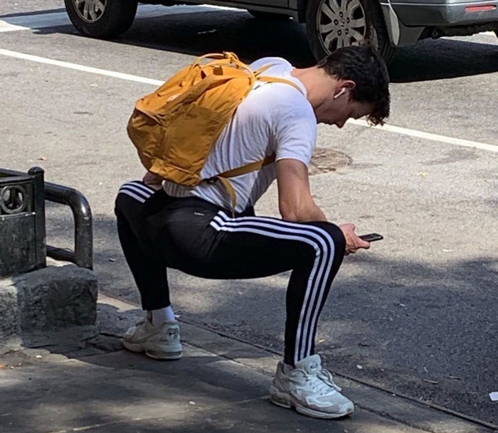 Persona haciendo una pose extraña mientras está parado en la calle