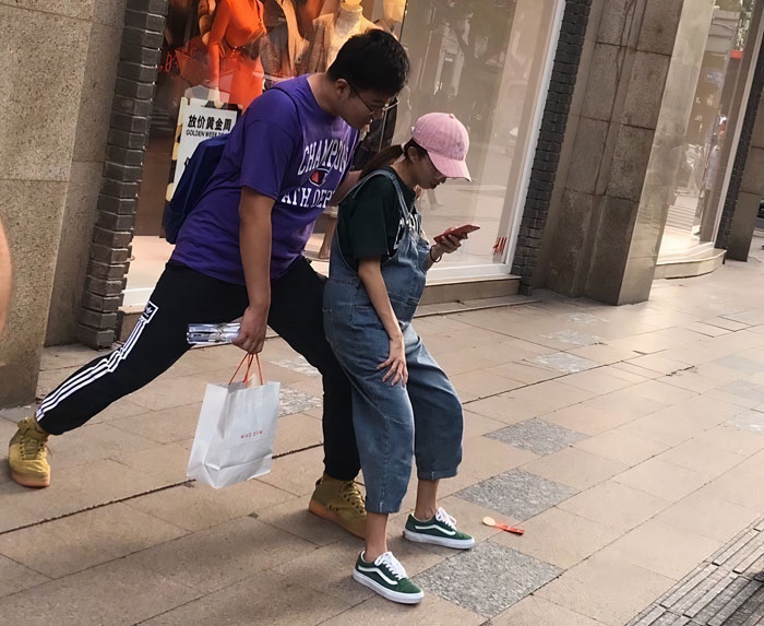 Persona haciendo una pose extraña mientras está parado en la calle