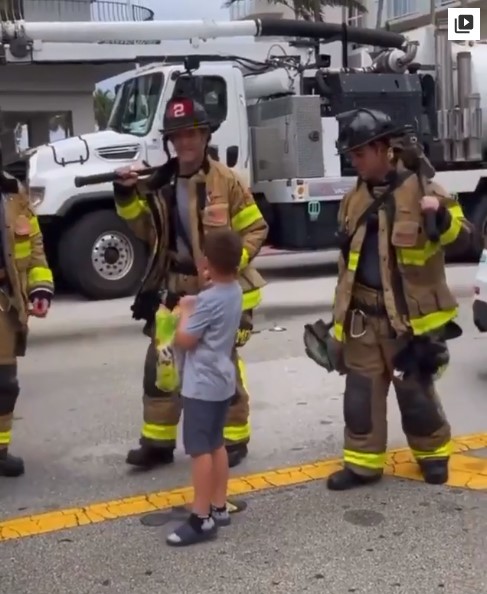 Niño repartiendo dulces a los bomberos en el derrumbe de Miami