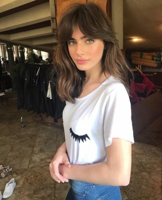 Chica usando un fleco estilo Waft con el cabello largo y esponjado en los laterales
