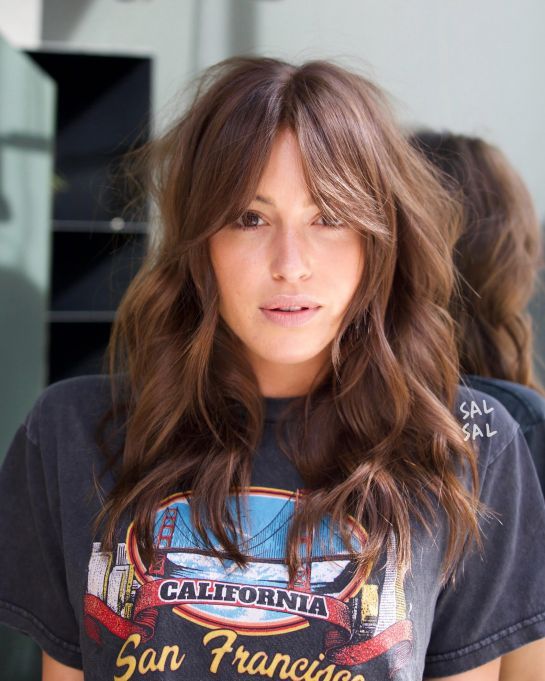 Chica con fleco estilo Waft y cabello largo teñido de castaño