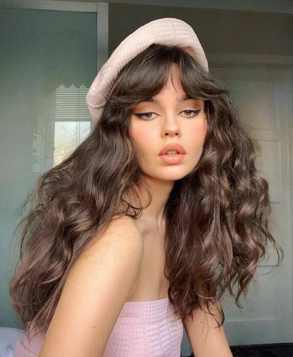 Chica usando un fleco estilo Waft con el cabello largo y sujetado en una coleta