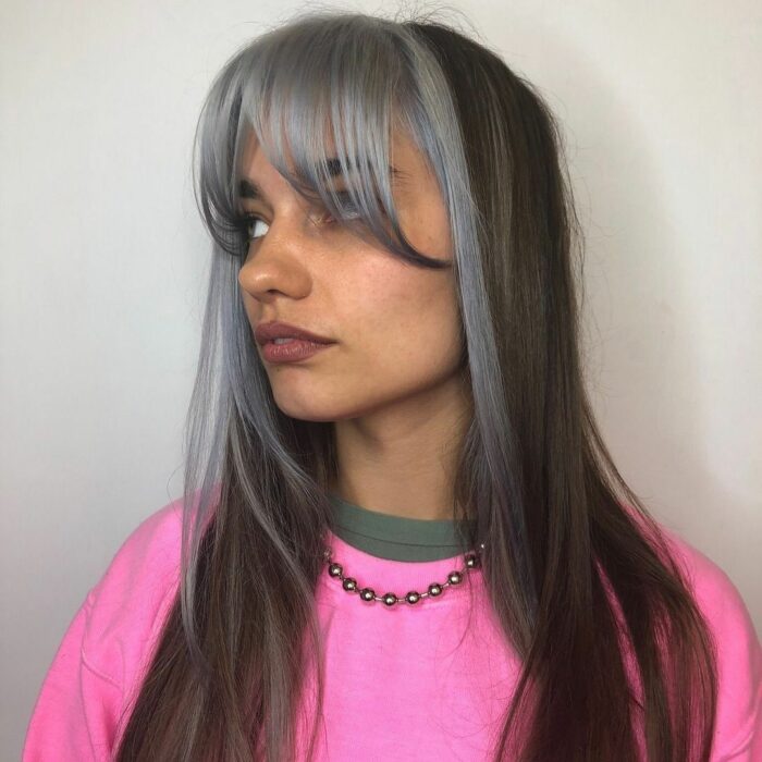 Chica usando un fleco estilo Waft con cabello gris y negro