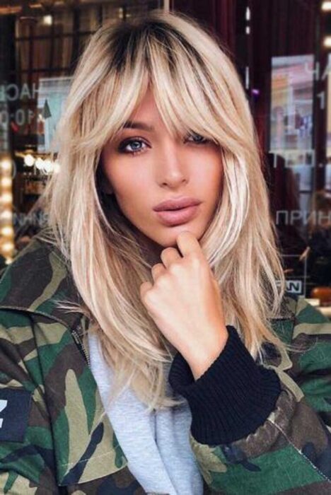 Chica usando un fleco estilo Waft con el cabello largo y esponjado