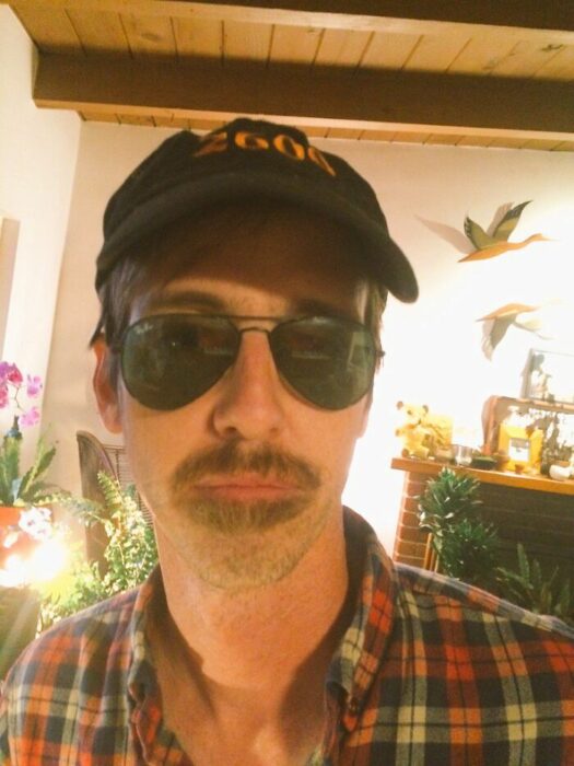 Hombres usando doble bigote en el rostro mientras lo peinan con gracia
