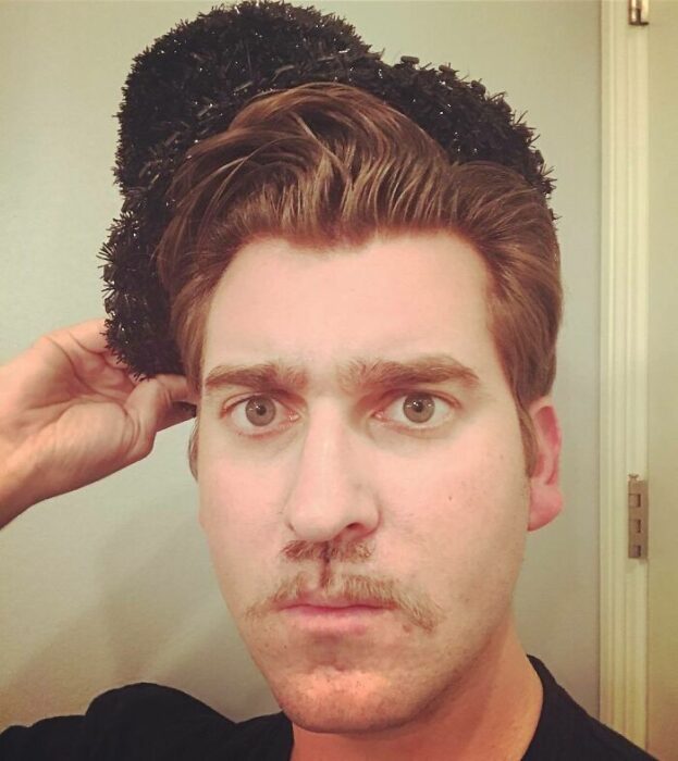 Hombres usando doble bigote en el rostro mientras lo peinan con gracia