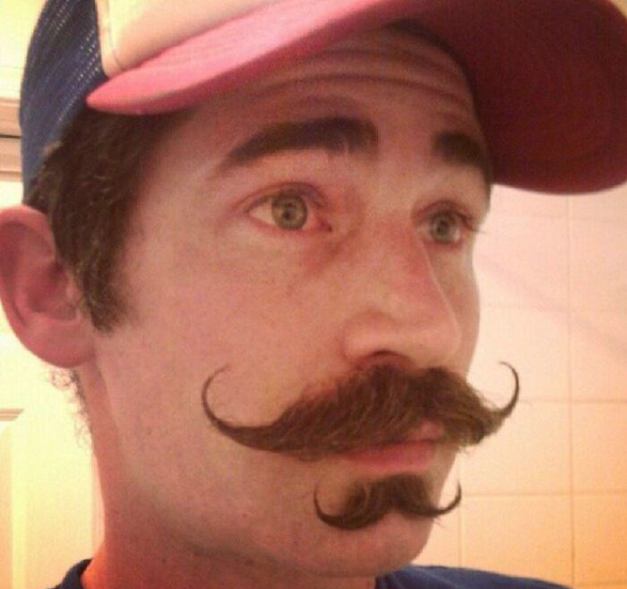 Hombres usando doble bigote en el rostro mientras lo peinan con gracia