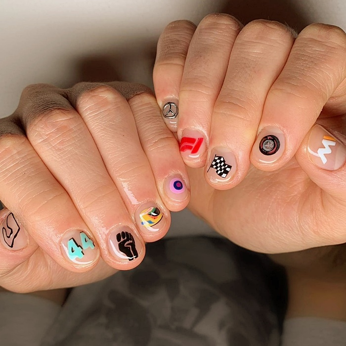 Hombre joven con manicura masculina, estilo moderno en negro, blanco, rojo, amarillo, azul y gris