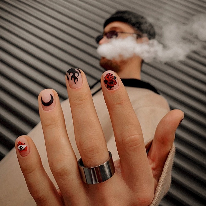 Hombre joven con manicura masculina, estilo moderno en negro, blanco, rojo, amarillo, azul y gris