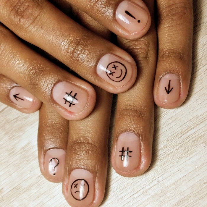 Hombre joven con manicura masculina, estilo moderno en negro, blanco, rojo, amarillo, azul y gris
