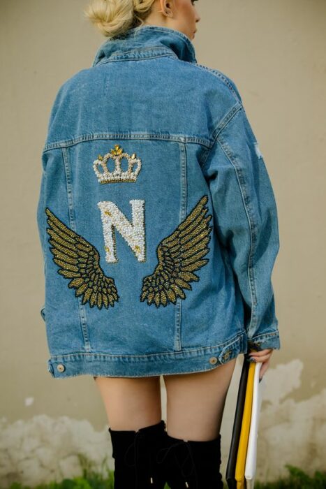 Chaqueta con un dibujo de alas en tonos dorados; 18 Ideas para renovar tu vieja chamarra de mezclilla