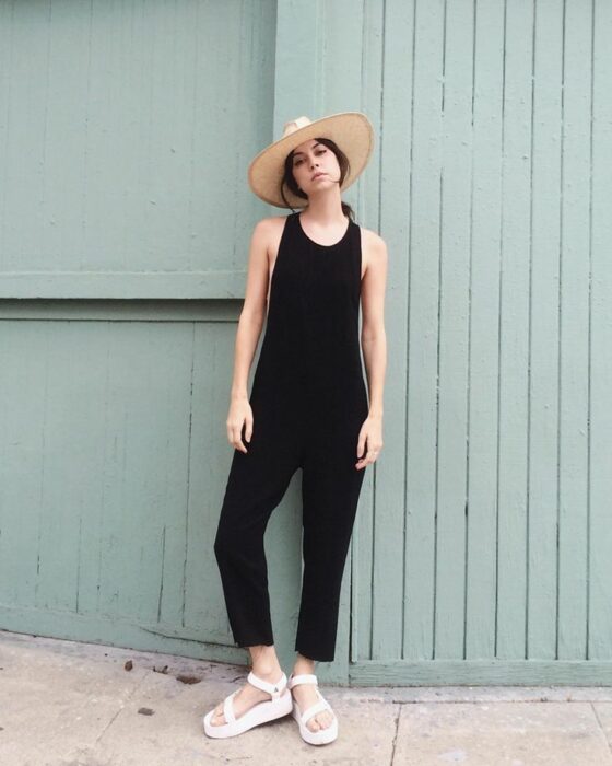 Chica usando un mono negro con sandalias de plataforma
