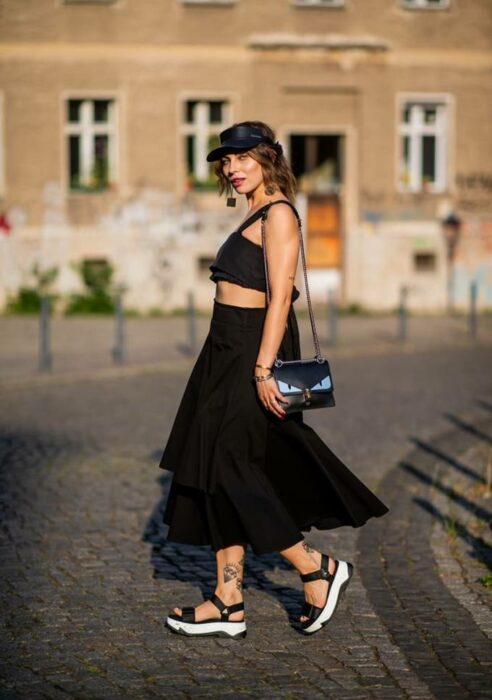 Chica con una falda larga y top, usando sandalias de plataforma