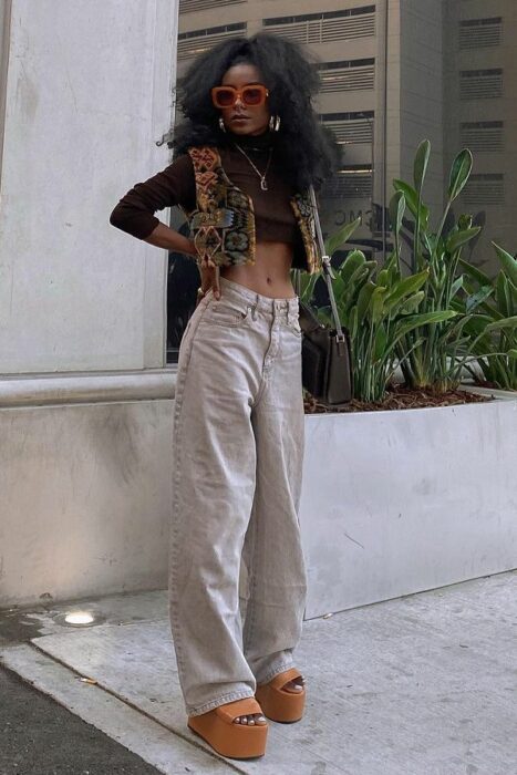 Chica con un look de pantalón de mezclilla y sandalias de plataforma