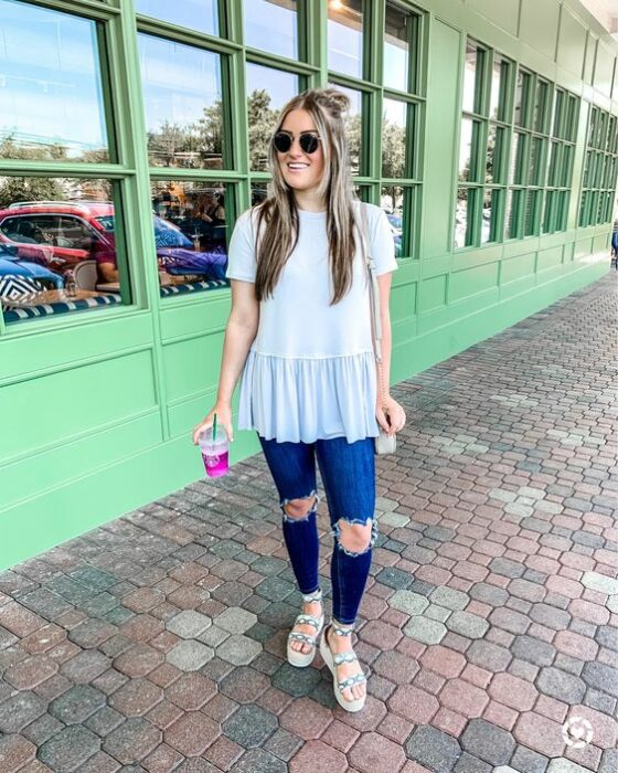 Chica con jeans, blusa azul y sandalias de plataforma