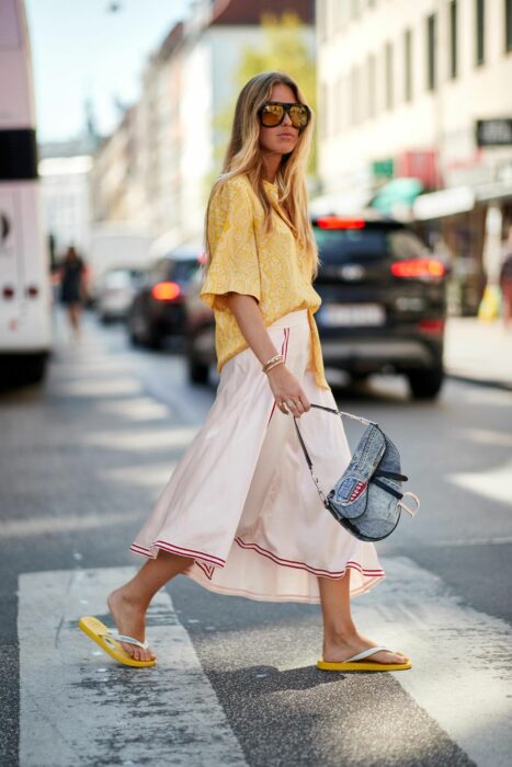 Chica usando unas sandalias flip flops con un pantalón culotte y una camisa amarilla
