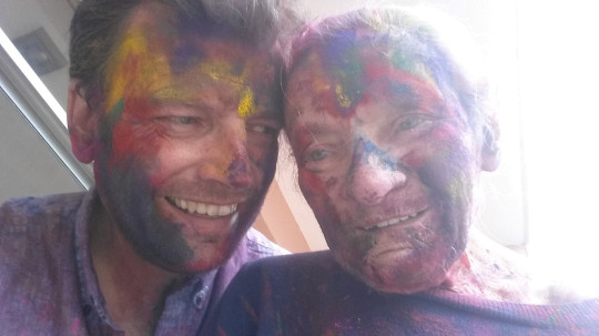 Hombre junto a su madre llenos de polvos de colores 