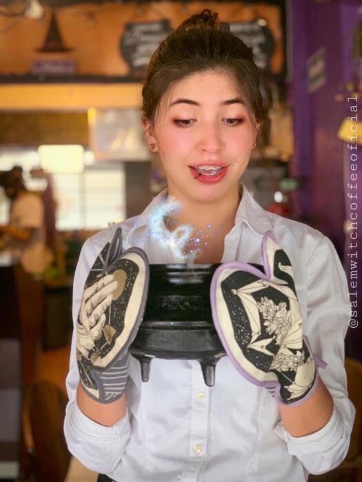 Chica sosteniendo un caldero; Esta cafetería inspirada en brujas sirve las mejores opciones del mundo oscuro