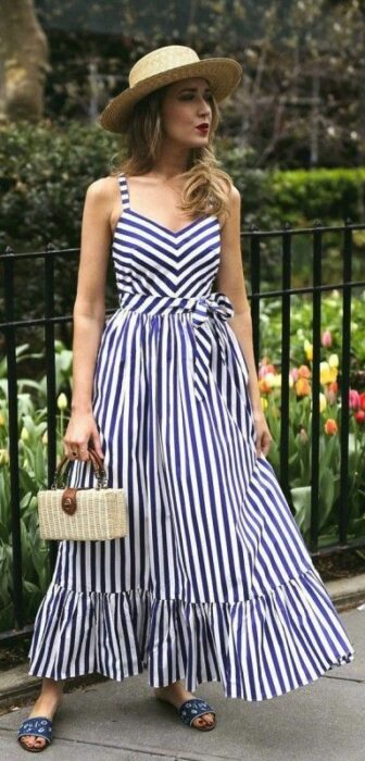 Chica usando un vestido azul de líneas con sandalias