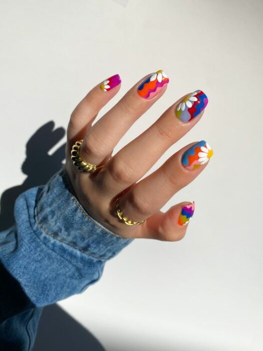 Chica con las uñas pintadas en diferentes colores