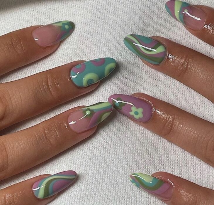 Chica con las uñas pintadas en tonos morados con verde