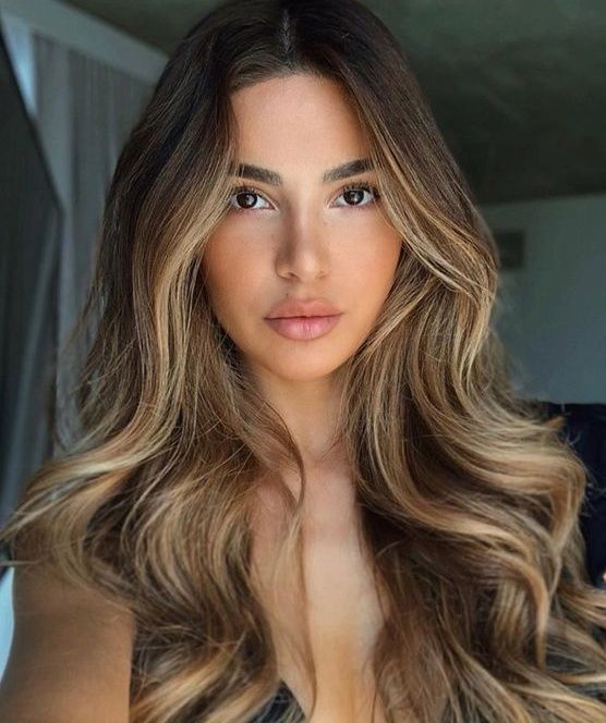 Chica con el cabello teñido en rubio con reflejos en tono caramelo