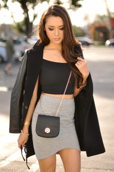 Chica posando para una fotografía mientras usa un bolso pequeñito
