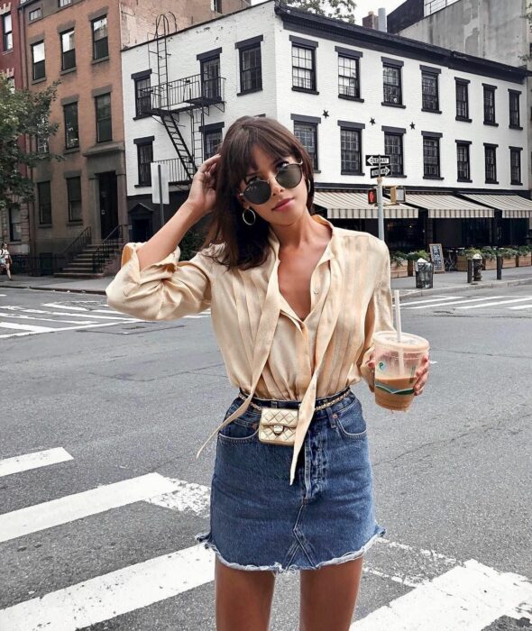 Chica posando para una fotografía mientras usa un bolso pequeñito