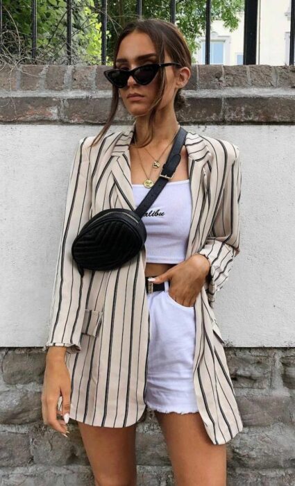 Chica posando para una fotografía mientras usa un bolso pequeñito