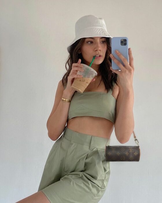 Chica posando para una fotografía mientras usa un bolso pequeñito