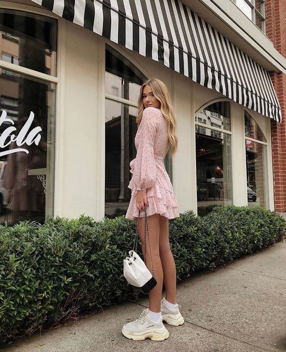 Chica posando para una fotografía mientras usa un bolso pequeñito