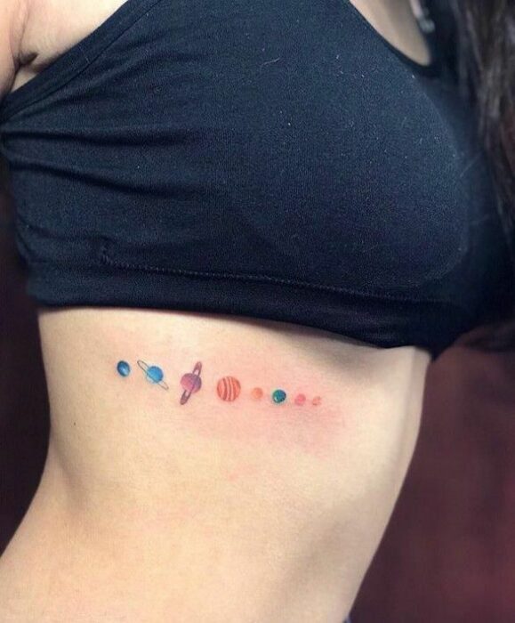 Chica con un tatuaje de planetas en varios colores
