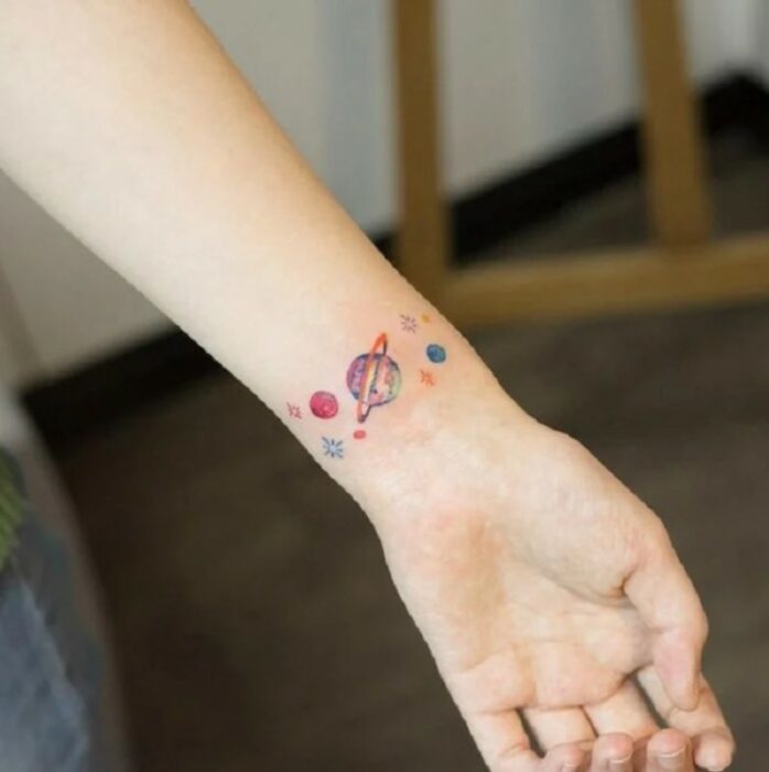 Chica con un tatuaje de planetas en varios colores