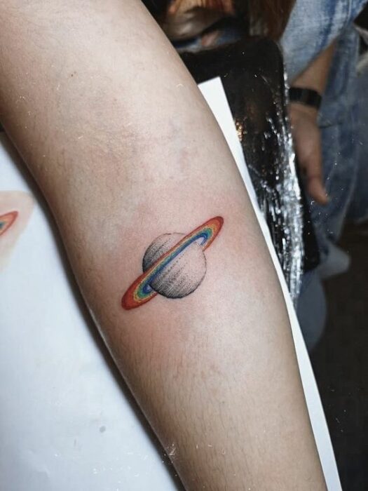 Chica con un tatuaje de planetas en varios colores