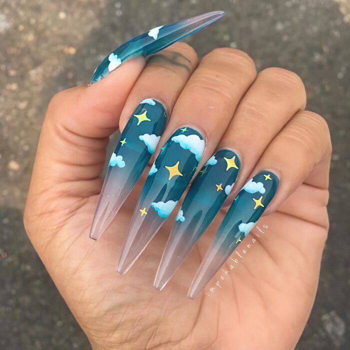 Chica con unas uñas extra largas con diseño de cielo y nubes
