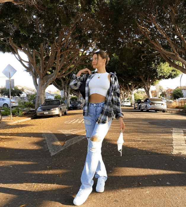 chica de cabello largo usando un crop top blanco, negro, beige, café, verde, azul de manga larga, corta, con jeans ajustados, pantalones negros de cuero, bolso pequeño de mano